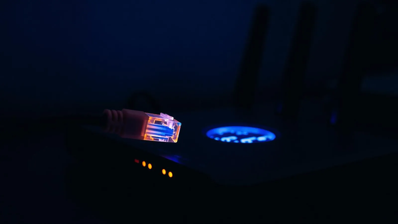 Cabo ethernet conectado a um roteador Wi-Fi moderno com LEDs acesos